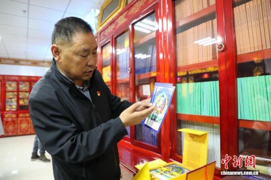 图为果洛州藏医院党委书记卓玛才旦介绍医院整理收藏的藏医药古籍。马铭言 摄