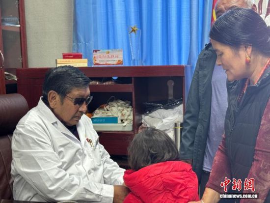 图为东杰(左一)为当地孩童把脉诊治。陈宗淇 摄