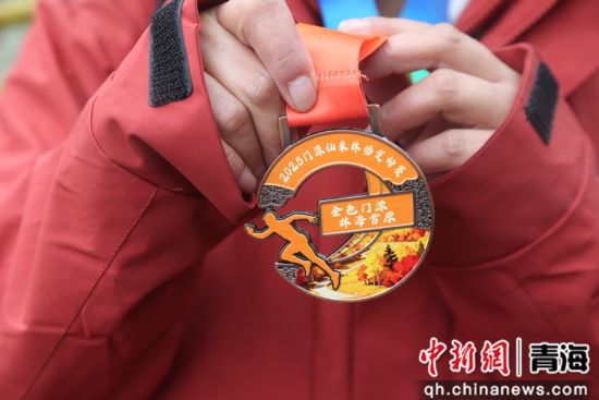 图为参赛选手展示完赛奖牌。 张忠苹 摄