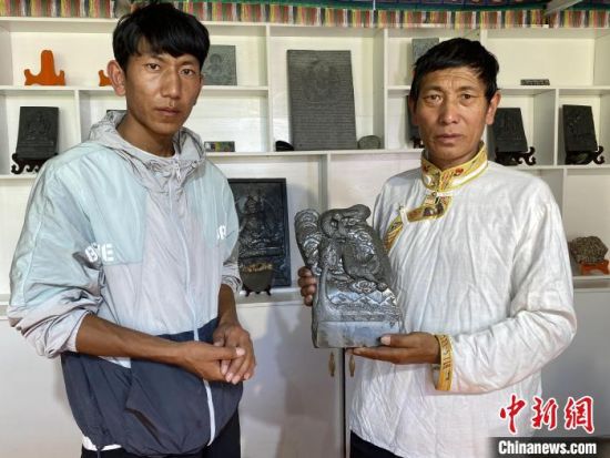 图为多节才旦(左)与才旦加(右)展示泽库和日寺石刻作品。受访者供图 图为多节才旦(左)与才旦加(右)展示泽库和日寺石刻作品。受访者供图