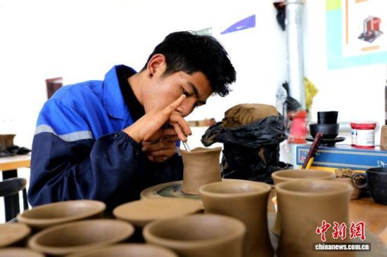 图为在班玛县电子商务公共服务中心黑陶体验馆中，艺人正在制作黑陶器具。马铭言 摄