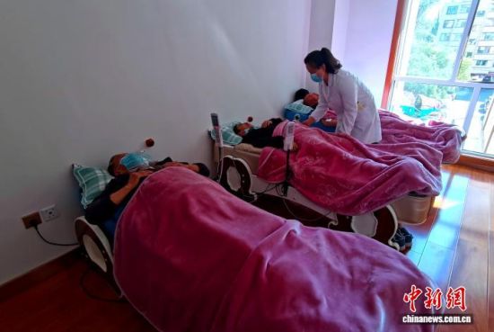 资料图为社区工作人员为辖区老人提供康复服务。李隽 摄