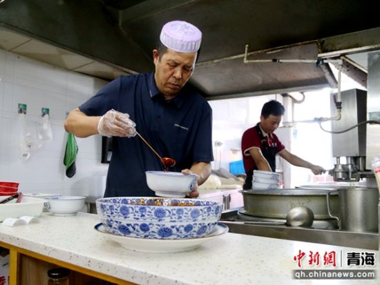 图为拉面老板冶子日正在厨房忙碌。张忠苹 摄