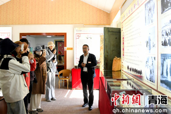 图为张存虎（右）向采访团成员介绍莫河驼场的历史。蔡得军摄