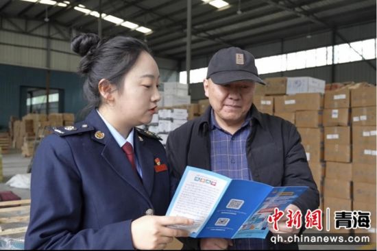 图为税务干部为物流企业讲解适用政策。 王利娜 摄 图为税务干部为物流企业讲解适用政策。 王利娜 摄