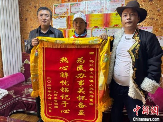 图为扎西东智(右)带着尕玛措(中)给董晖(左)赠送锦旗。陈宗淇 摄 图为扎西东智(右)带着尕玛措(中)给董晖(左)赠送锦旗。陈宗淇 摄