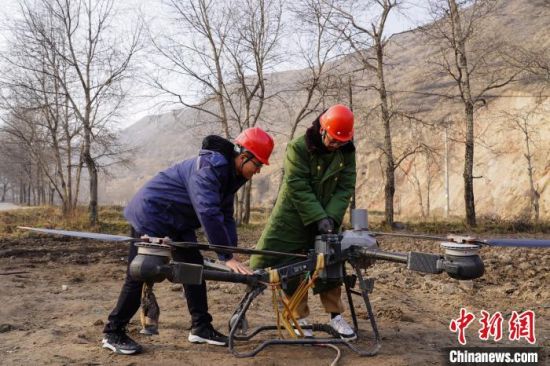 图为国网西宁供电公司工作人员在35千伏前营变电站增容扩建现场给无人机更换电池。沈仪 摄 图为国网西宁供电公司工作人员在35千伏前营变电站增容扩建现场给无人机更换电池。沈仪 摄