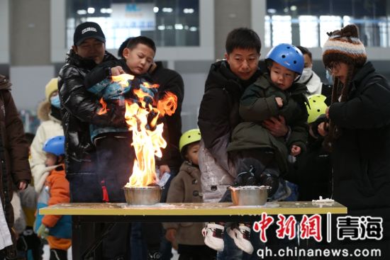 图为家长和孩子正在体验“燃烧的水”项目。张忠苹摄