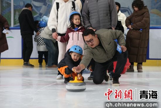 图为家长和孩子正在参加“亲子冰壶”项目比赛。张忠苹摄